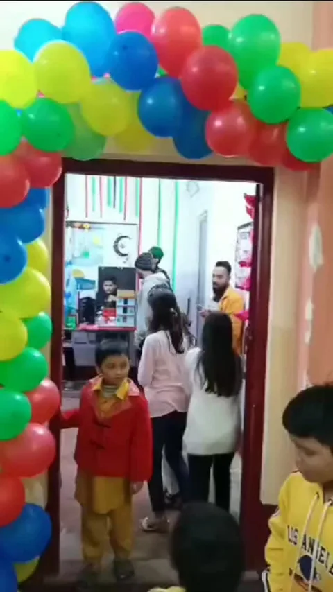 Children entering a classroom decorated with a colourful balloon arch for the NMS Annual Exhibition